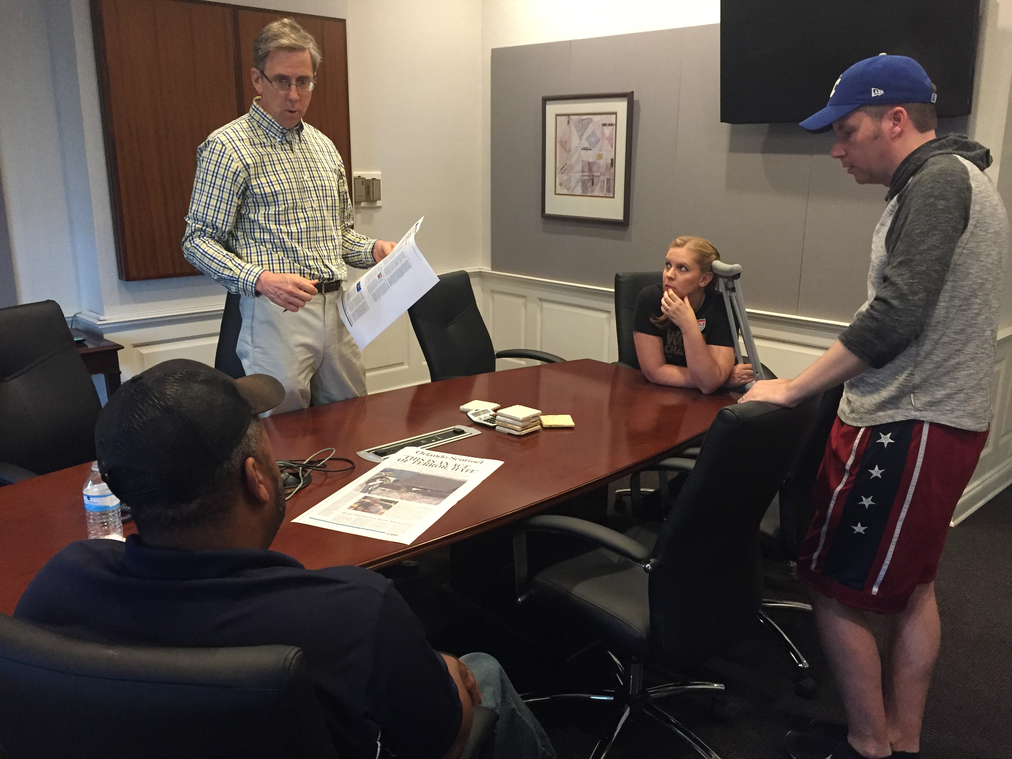 Editors discuss Monday's front page on Sunday. Pictured here, from left, are Avido Khahaifa, editor and publisher, Paul Owens, opinions editor, Cassie Armstrong, photo and video editor, and Todd Stewart, senior editor for multimedia and visuals. (Photo by Kristen Hare/Poynter)