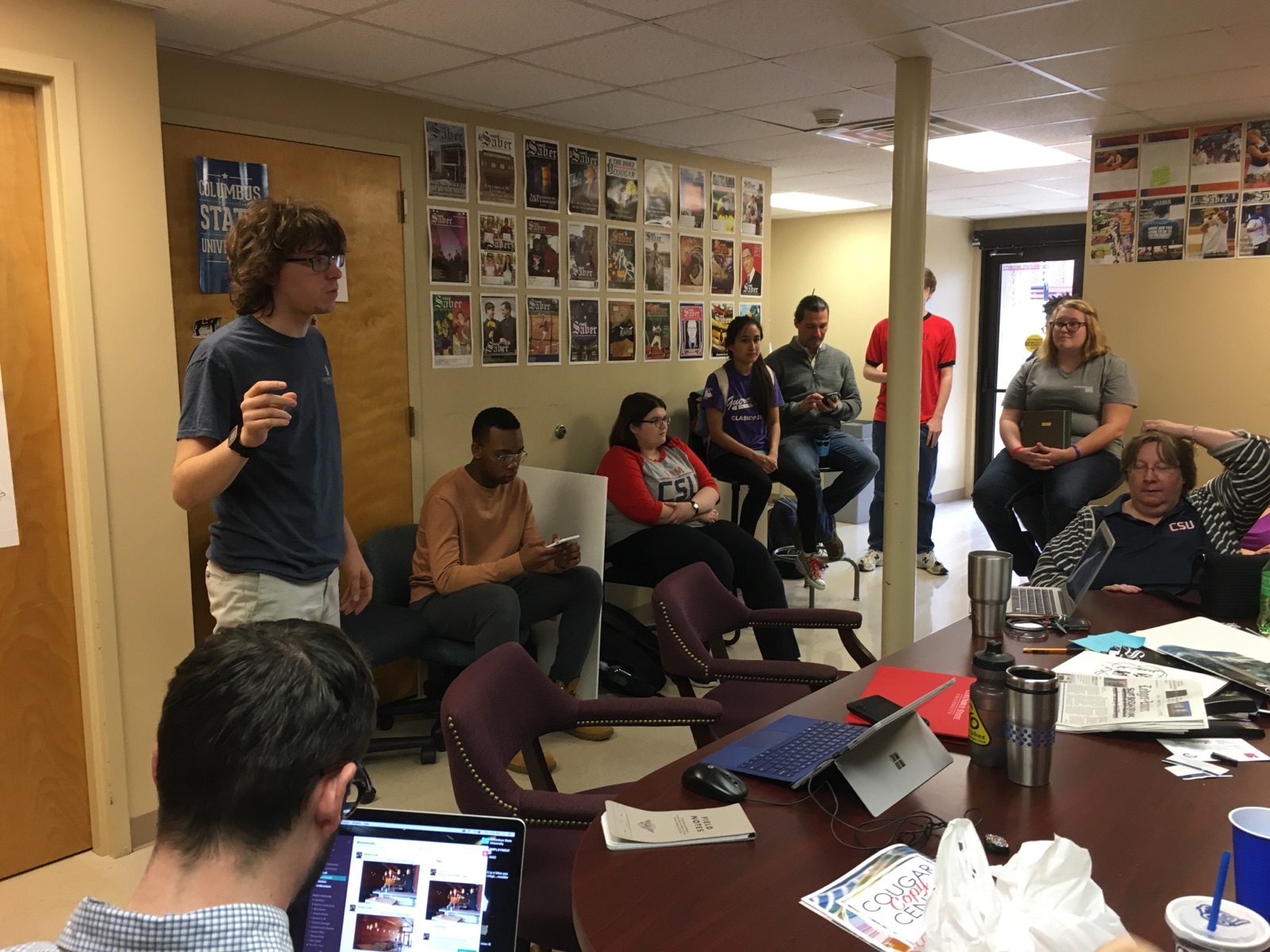 (Scott Berson, standing, leads a news meeting at The Saber, submitted photo)