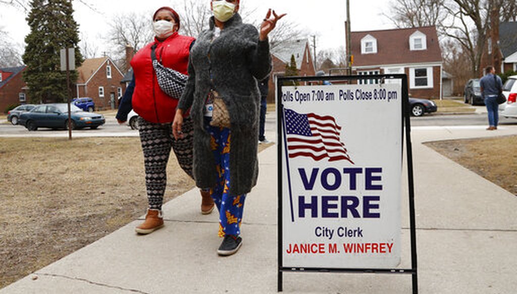 Voters go to the polls in masks.