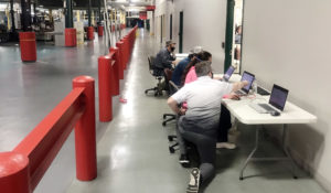 Gazette editors work in a corridor at the printing press, plugged directly into the server to produce the newspaper on Tuesday, Aug. 11, 2020. (Liz Martin/The Gazette)