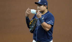 Tampa Bay Rays first baseman Ji-Man Choi puts on a protective face mask as he waits for Miami Marlins' Jesus Aguilar to get to first base during the fourth inning of a baseball game Saturday, Sept. 5. (AP Photo/Chris O'Meara)