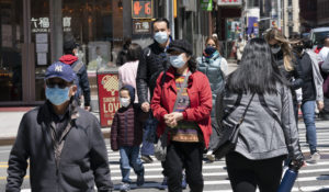 People walk on the street, Monday, April 26, 2021 in New York. (AP Photo/Mark Lennihan)