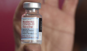 A health worker shows a the Moderna vaccine for COVID-19, donated by the U.S. government, at a health center in Quilmes Argentina, Tuesday, Aug. 3, 2021. (AP Photo/Gustavo Garello)