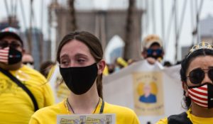 A person with tears in their eyes walks across the Brooklyn Bridge with other COVID survivors last Saturday in New York. (AP Photo/Stefan Jeremiah)