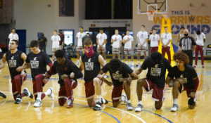 FILE - In this Jan. 9, 2021, file photo, Washington State players kneel during the national anthem in front of standing Stanford players before an NCAA college basketball game in Santa Cruz, Calif. Student-athletes across college campuses are taking a lead from professional athletes by using their platforms in hopes of creating change.  (AP Photo/Jeff Chiu, File)