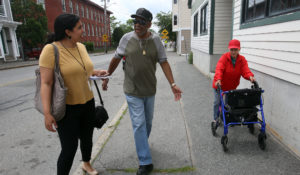 From left: Amaris Castillo, then a reporter for The Sun in Lowell, Massachusetts, accompanies Ismael Rodriguez and Margarita Garcia Lozada, on their daily walk for a feature story in 2019. (Julia Malakie/The Sun)