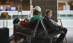 Travelers sit in a waiting area at Rhode Island T.F. Green International Airport in Providence, R.I., Tuesday, April 19, 2022. A federal judge's decision to strike down a national mask mandate was met with cheers on some airplanes but also concern about whether it's really time to end one of the most visible vestiges of the COVID-19 pandemic. (AP Photo/David Goldman)