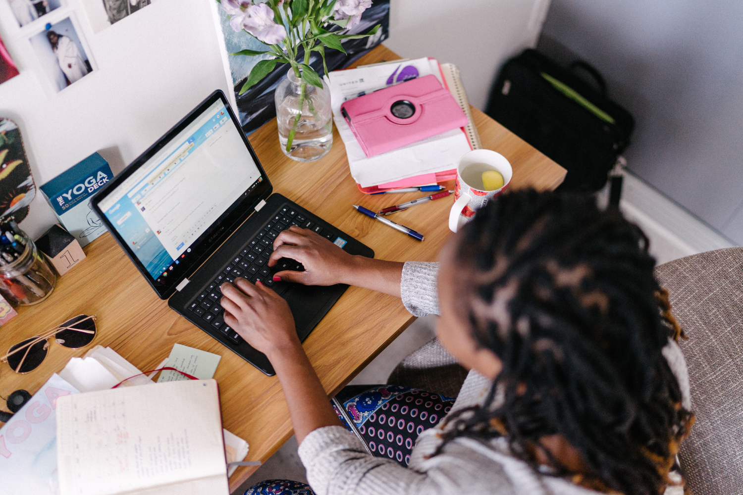 A woman types an email on her computer