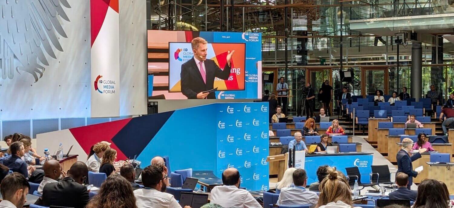 Thomas Sparrow moderating in front of an audience at the Global Media Forum