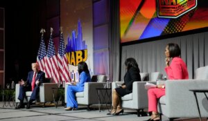 Republican presidential candidate former President Donald Trump, left, speaks at the National Association of Black Journalists convention on Wednesday in Chicago. He is being interviewed by, from left to right, ABC's Rachel Scott, Semafor's Nadia Goba and Fox News' Harris Faulkner. (AP Photo/Charles Rex Arbogast)