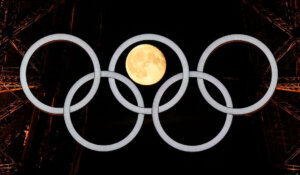 A full moon rises behind the Olympic rings hanging from the Eiffel Tower in Paris on Monday. (AP Photo/David J. Phillip)