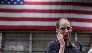 Evan Gershkovich talks on the phone after he arrived at Kelly Field after being released by Russia, Friday, Aug. 2, 2024, in San Antonio. (AP Photo/Eric Gay)