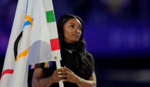 United States' gymnast Simone Biles holds the Olympic flag during the 2024 Summer Olympics closing ceremony in Paris on Sunday. (AP Photo/Natacha Pisarenko)