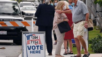 People gather outside a polling place located at the Morton and Barbara Mandel Recreation Center, Tuesday, Nov 3, 2020, in Palm Beach, FL,  (AP Photo/Jim Rassol)