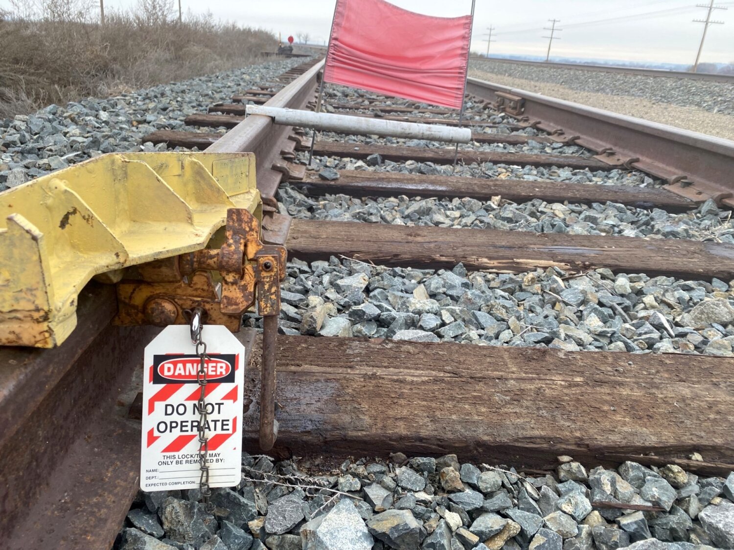 A close-up of railroad tracks that are flagged with a sign that reads "Danger. Do not operate."