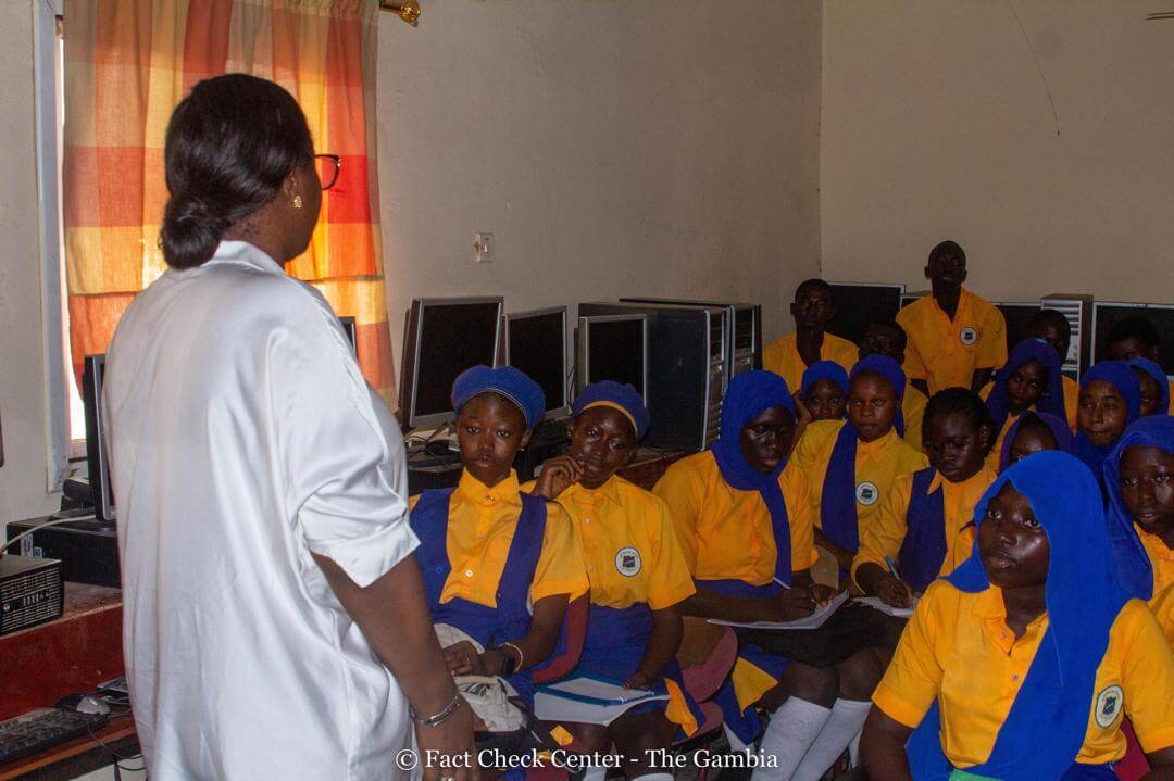 Students sitting in desks while Mariama Danso talks with them.