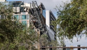 Photo of a crane that fell during Hurricane Milton on the building that houses the Tampa Bay Times news outlet in St. Petersburg, Fla. (AP Photo/Mike Carlson)