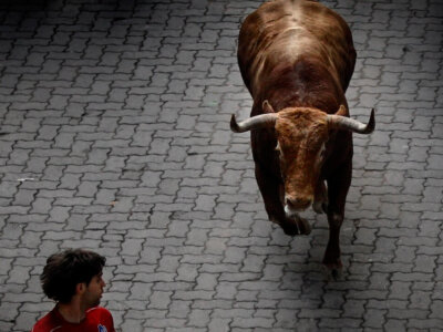 A revelers is chased by a Torrehandilla's ranch fighting bulls during the running of the bulls of the San Fermin, in Pamplona, Spain, Saturday, July 14, 2012.(AP Photo/Daniel Ochoa de Olza)